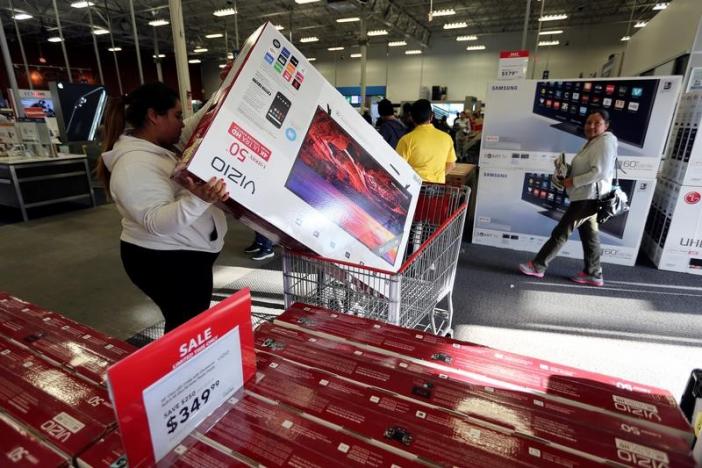 A woman puts a television product in her cart during Black Friday sales at a Best Buy store in Los Angeles