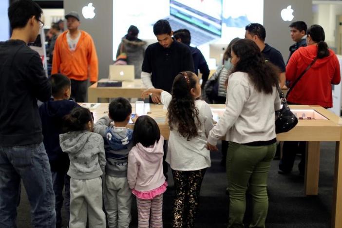 A family looks at Apple products during Black Friday sales at a Best Buy store in Los Angeles