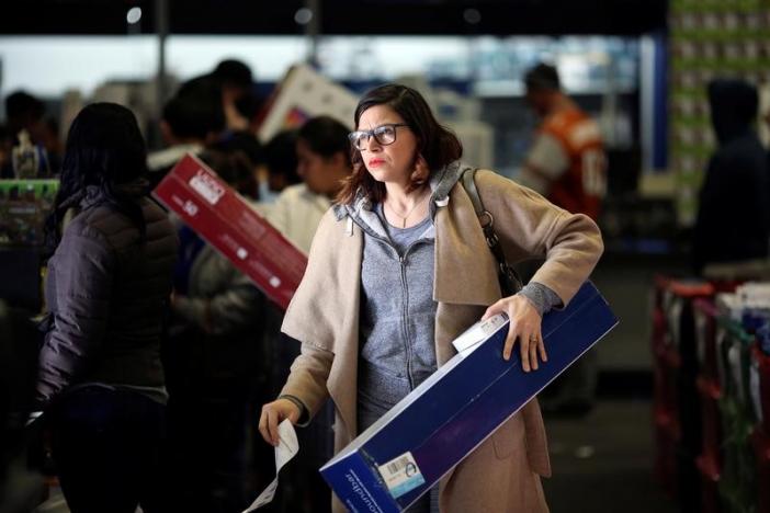 People leave the store with their purchases during Black Friday sales at a Best Buy store in Los Angeles