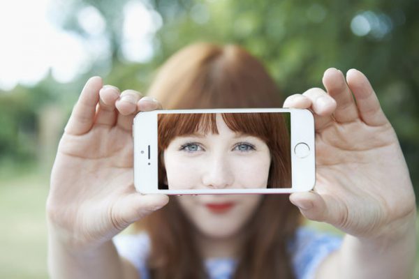 woman holding up mobile with selfie