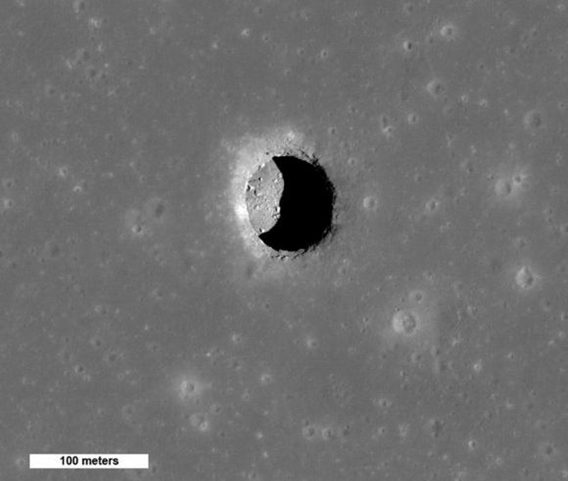 Вид на кратер ями Маре Транквілітатіс під високим сонцем, де видно валуни на гладенькій підлозі. 100-метрова яма може забезпечити доступ до місячної лавової труби
